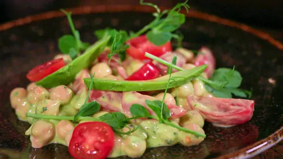 Ein Teller mit Kircherebsen und Avocado-Joghurt-Dressing.