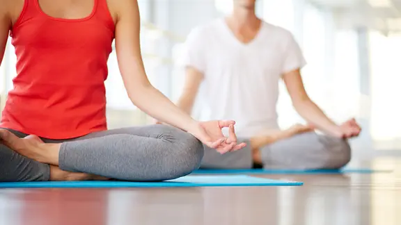 Zwei Personen sitzen in Yogahaltung auf Matten. | colourbox, Pressmaster Zwei Personen sitzen in Yogahaltung auf Matten.