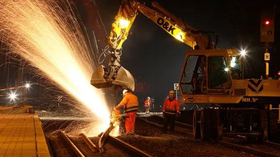 Gleisbauarbeiter wechseln in der Nacht eine Weiche aus .
