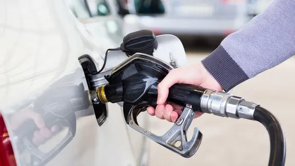 Benzin wird mit einer Zapfpistole in ein Auto gepumpt.