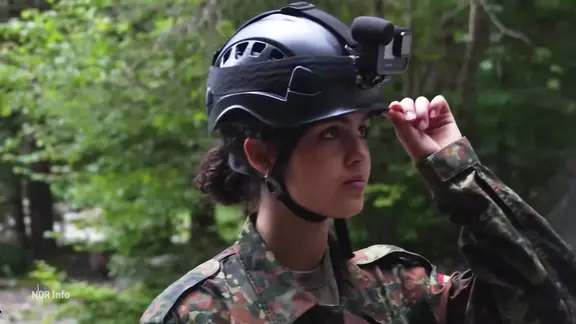 Eine junge Soldatin der Bundeswehr trägt einen Helm mit GoPro.