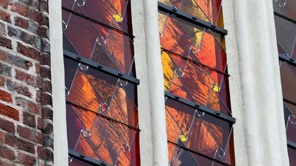 Auch von außen ein Hingucker: Ólafur Elíassons vom Friedrich-Gemälde "Huttens Grab" inspirierte Kirchenfenster. | Bernd Wüstneck/dpa Ein Teil der von Ólafur Elíasson gestalteten Fenstergruppe im Greifswalder Dom, von außen betrachtet.