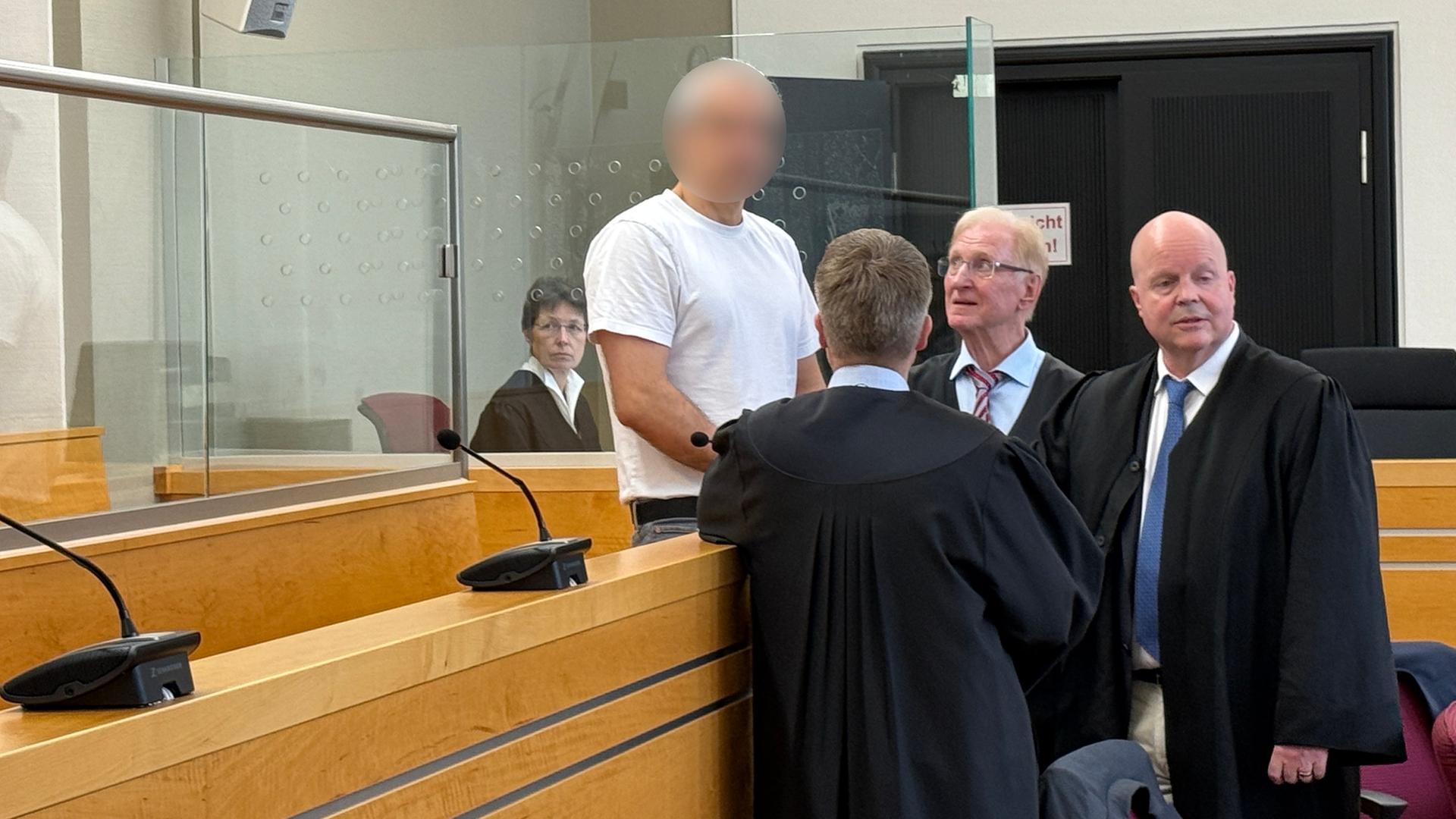 Ein angeklagter Arzt unterhält sich vor Prozessbeginn im Landgericht Hannover mit seinen Anwälten. | NDR, Niels Christoph