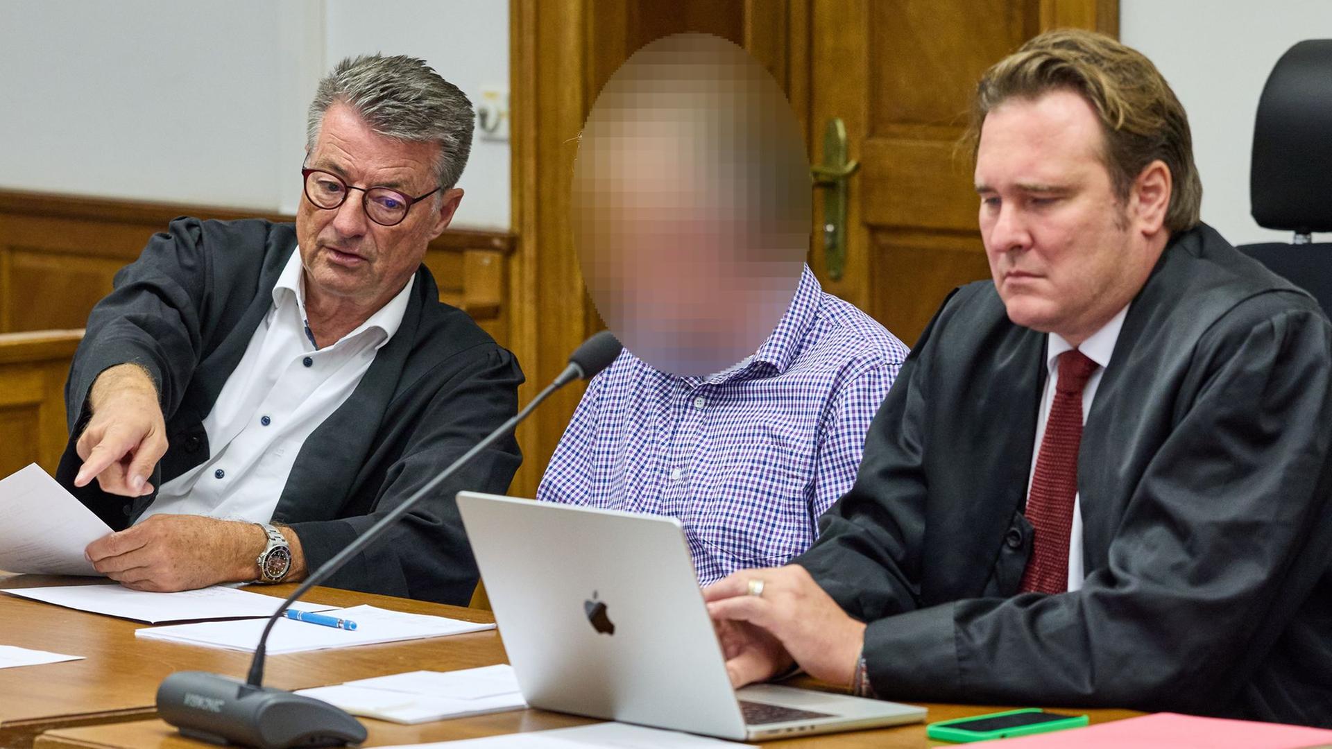 Ein Angeklagter sitzt vor Beginn des Prozesses im Gerichtssaal des Landgerichts Lüneburg zwischen seinen Anwälten Rüdiger Proest (l) und Christoph Grabitz. | dpa-Bildfunk, Georg Wendt