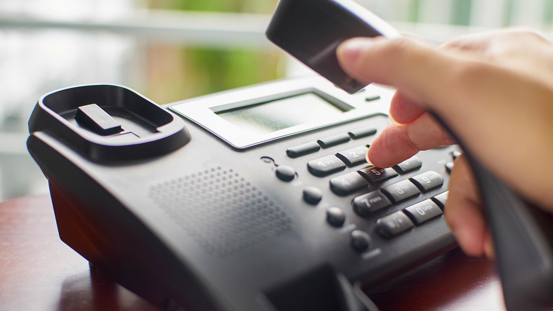 Eine Hand hebt den Telefonhörer ab. | Colourbox, jamesteohart