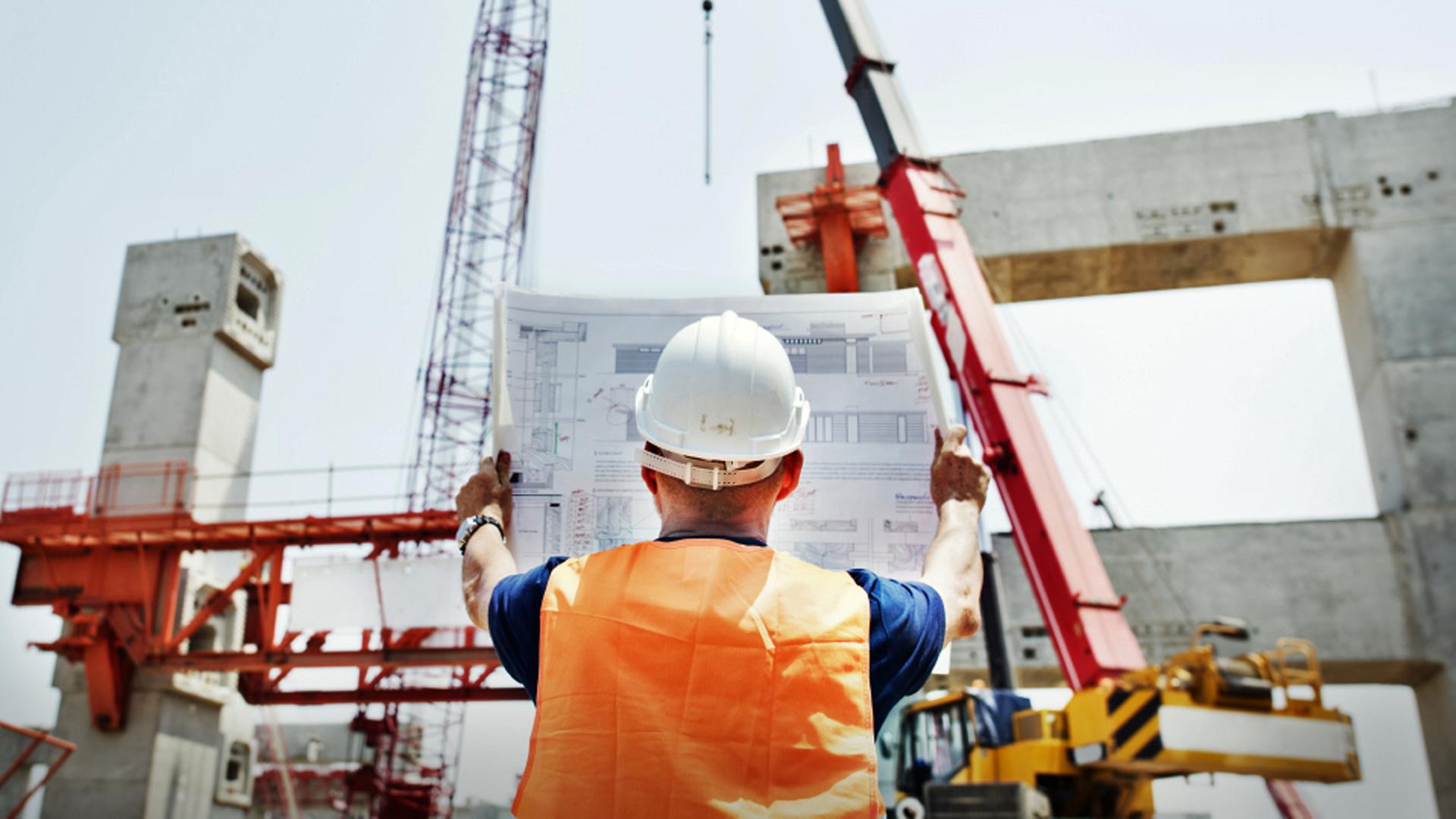 Ein Bauarbeiter schaut sich einen Bauplan auf einer Baustelle an. | fotolia, Rawpixel.com