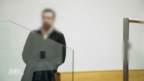 Ein Angeklagter steht im Gerichtssaal