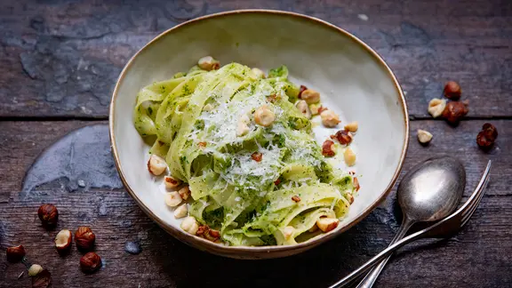 Nudeln mit Haselnuss-Petersilien Pesto auf einem Teller serviert.