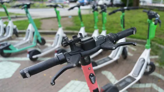 Mehrere E-Scooter stehen vor dem Bahnhof Harburg.