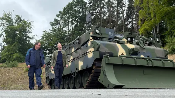 Zweio Personen neben einem Panzer des Typs "WISENT II"