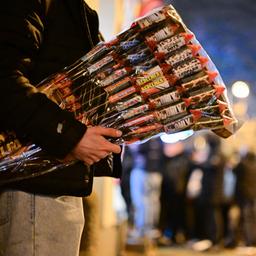 Ein Mann hält beim Verkaufsstart von Silvesterfeuerwerk Feuerwerksartikel Raketen unter seinem Arm.