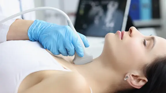 Eine Frau wird per Ultraschall an der Schilddrüse untersucht.