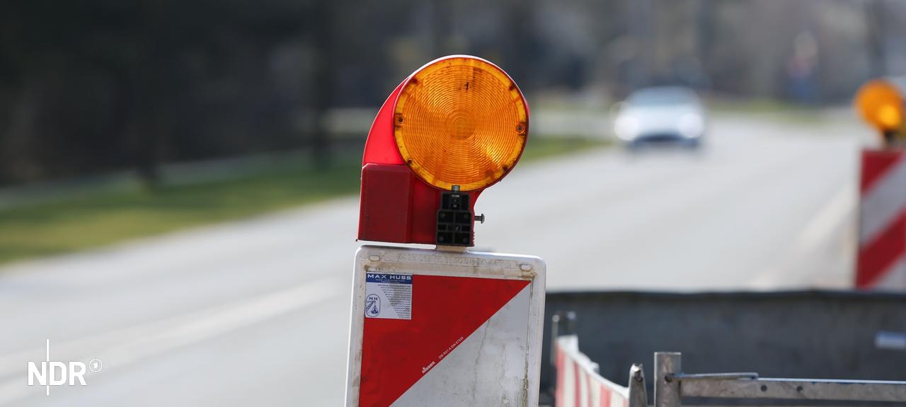 Baustellenbaken und Absperrzaun stehen am Straßenrand. | NDR, Pavel Stoyan Baustellenbaken und Absperrzaun stehen am Straßenrand.