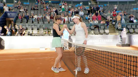 Zwei Tennisspielerinnen geben sich die Hand.