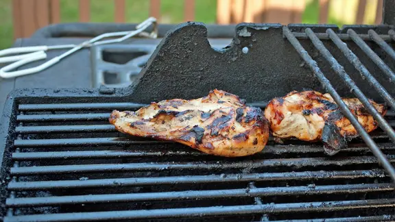 Zwei Hähnchenbrustfilets mit verbrannten Stellen auf einem Grillrost