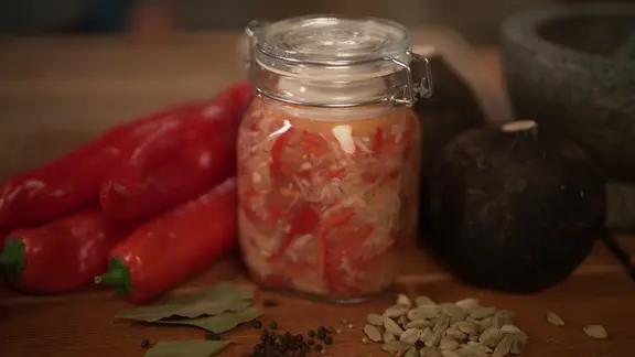 Ein Einmachglas mit Rettich auf einem Tisch angerichtet.