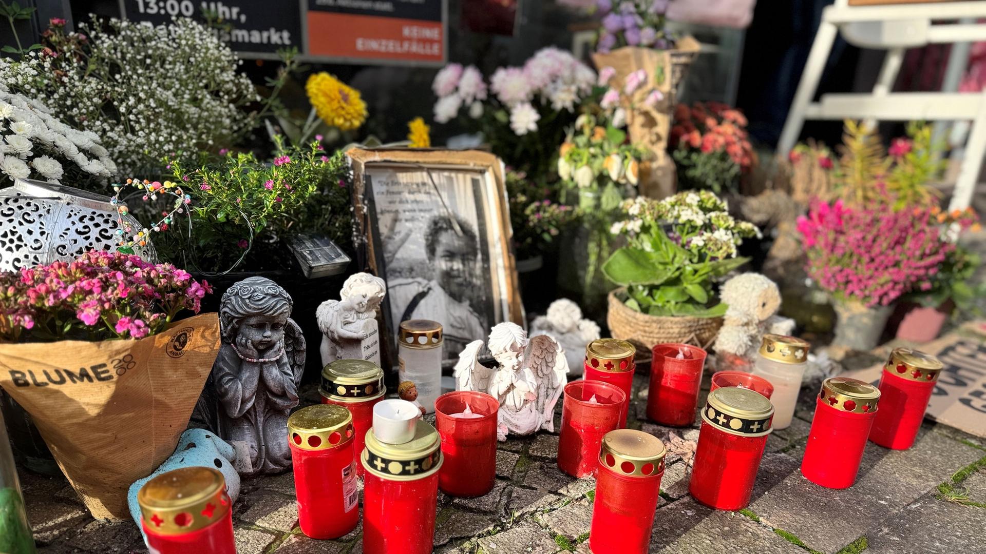Auf einer Straße stehen Trauerkerzen, Blumen, ein Engel und ein Bild. | NDR, Pascal Klug