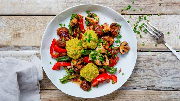 Ein Teller mit Pilz-Gemüse-Ragout steht auf einem Tisch.