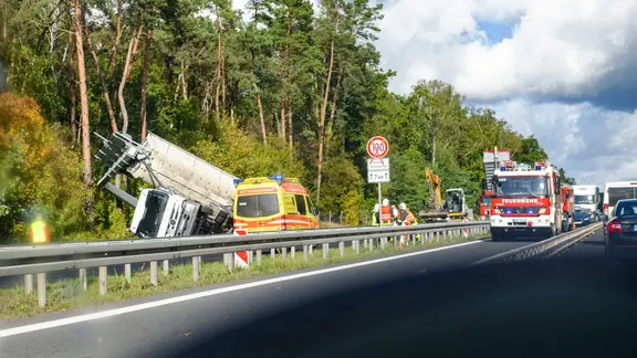 Ein Auto fährt bei Stau auf der Autobahn an einem Unfall vorbei.