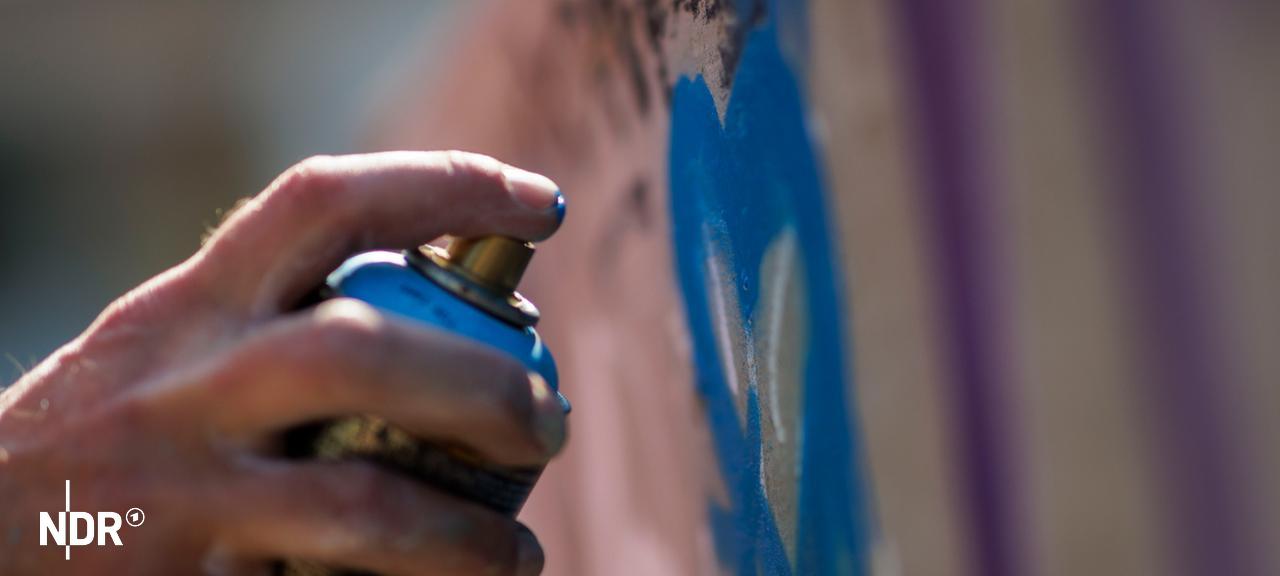 Jemand sprüht mit einer Spraydose ein Graffiti an eine Wand. | picture alliance / photothek.de, Kira Hofmann Jemand sprüht mit einer Spraydose ein Graffiti an eine Wand.