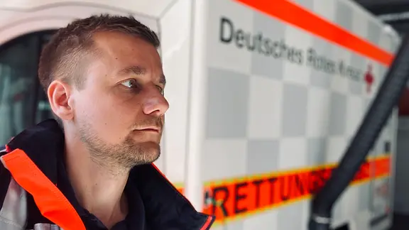 Tobi Schlegl vor einem Rettungswagen.