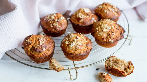 Bananenmuffins liegen zum Auskühlen auf einem Kuchengitter.