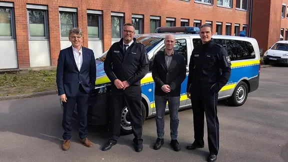 Beamte stehen vor der Polizeidienstelle Neumünster.
