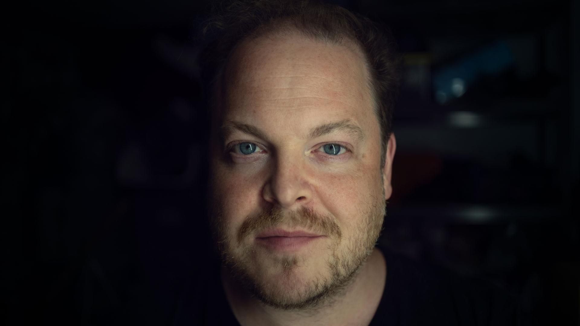 Der Tenor Andrew Staples schaut direkt in die Kamera, der Hintergrund ist schwarz | Andrew Staples, Andrew Staples