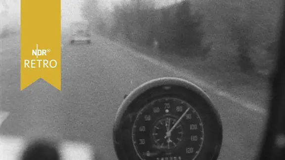 Blick aus einem PKW mit Tacho in den 1950er Jahren bei einer Autobahnfahrt.