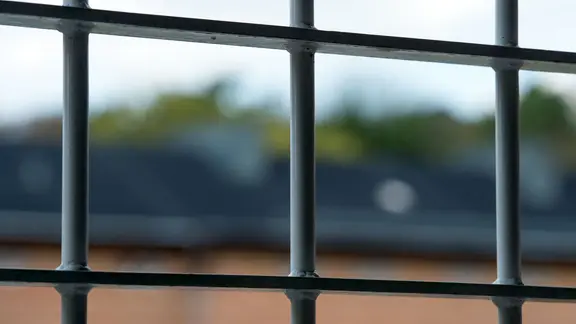 Blick durch ein vergittertes Fenster im Maßregelvollzug