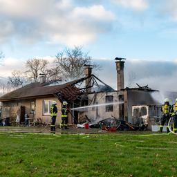 Feuerwehrleute löschen ein brennendes Wohnhaus