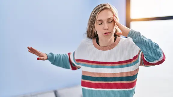 Eine Frau versucht, das Gleichgewicht zu halten. Ihr ist schwindlig.