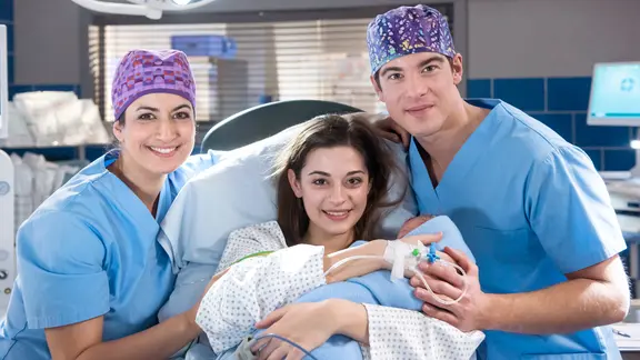 Leyla Sherbaz (Sanam Afrashteh, l.) und Ben Ahlbeck (Philipp Danne, r.) freuen sich über die glückliche Geburt von Zoes (Melina Fabian, M.) Baby.