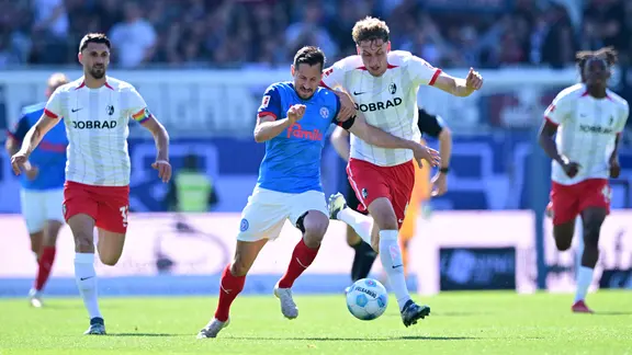 Kiels Steven Skrzybski (l.) und Freiburgs Patrick Osterhage kämpfen um den Ball.