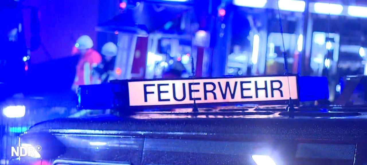 Ein Feuerwehr-Fahrzeug mit dem Schriftzug Feuerwehr steht bei Nacht vor einem Einsatzort, im Hintergrund sind Feuerwehrleute zu sehen. | NonstopNews Ein Feuerwehr-Fahrzeug mit dem Schriftzug Feuerwehr steht bei Nacht vor einem Einsatzort, im Hintergrund sind Feuerwehrleute zu sehen.