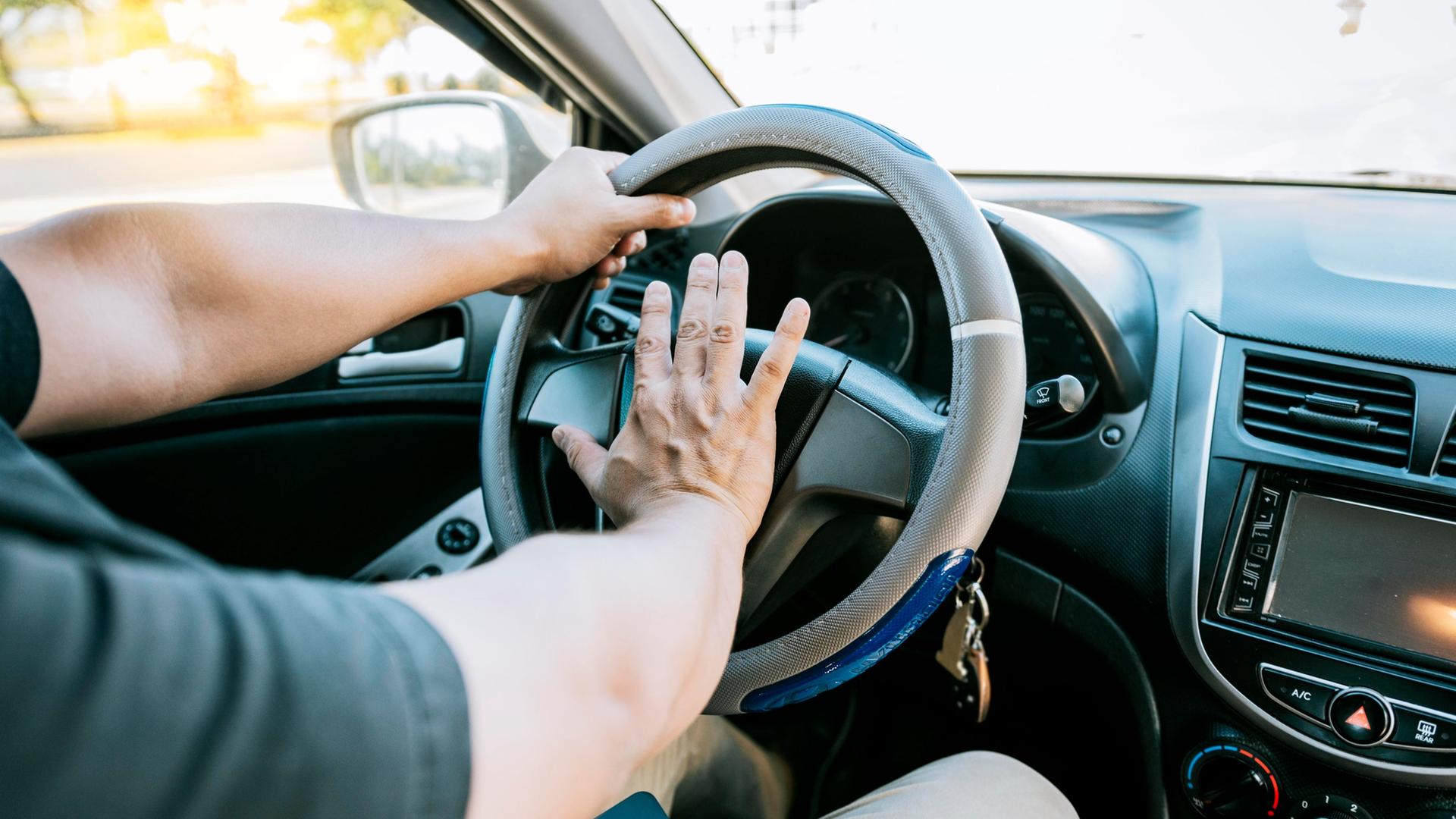 Eine Hand betätigt die Hupe eines Autos. | picture alliance / imageBROKER | Isai Hernandez