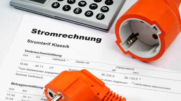 Eine Stromrechnung mit Stecker und Taschenrechner.