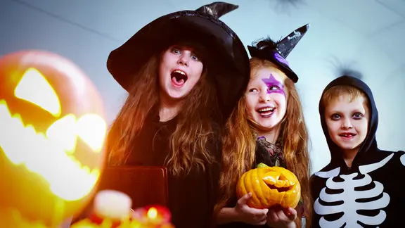 Früher versuchten die Menschen, die bösen Geister mit kleinen Gaben zu besänftigen. Heute spuken vor allem Kinder und lassen sich Süßes aushändigen. | Colourbox, Pressmaster Kindern in Kostümen feiern Halloween.