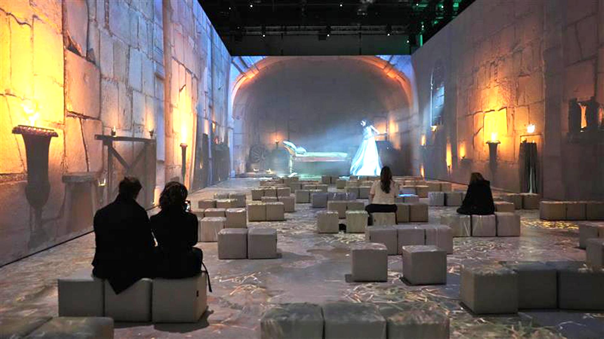 Mehrere Menschen sitzen in London vor einer Wand, an die Bilder aus dem alten Ägypten projiziert sind. | IMAGO / Anadolu Agency