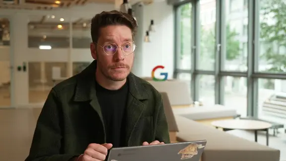 Der Pressesprecher von Google Deutschland, Philipp Gooding, hält die Bedenken der Verlage vor zu viel KI in den Suchergebnissen für unbegründet. | Screenshot Google-Sprecher Philipp Gooding im Interview.