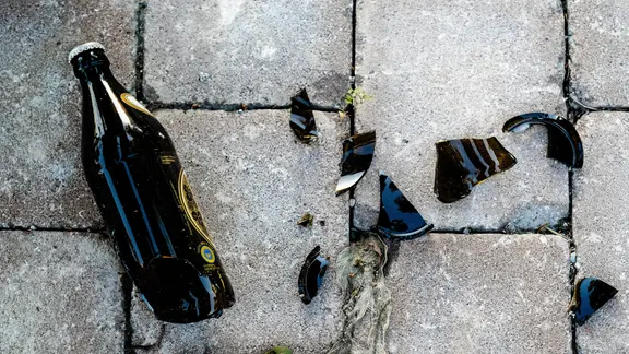 zerbrochene Bierflasche auf Pflastersteinen