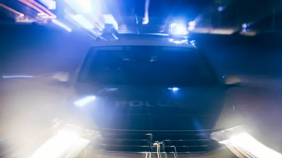 Das Bild zeigt einen Streifenwagen der Polizei Hannover in Unschärfe.