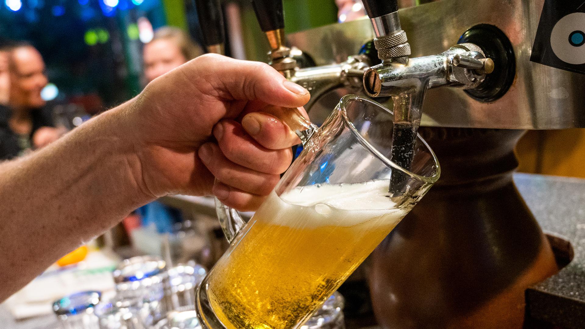 Ein Bier wird an einem Tresen gezapft. | picture alliance/Christophe Gateau/dpa, Christophe Gateau
