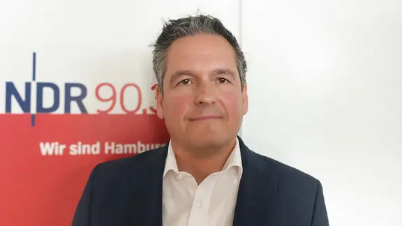 Ein Mann schaut in die Kamera.