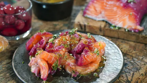 Graved Lachs mit Sauerkirsch-Beize auf einem Teller serviert