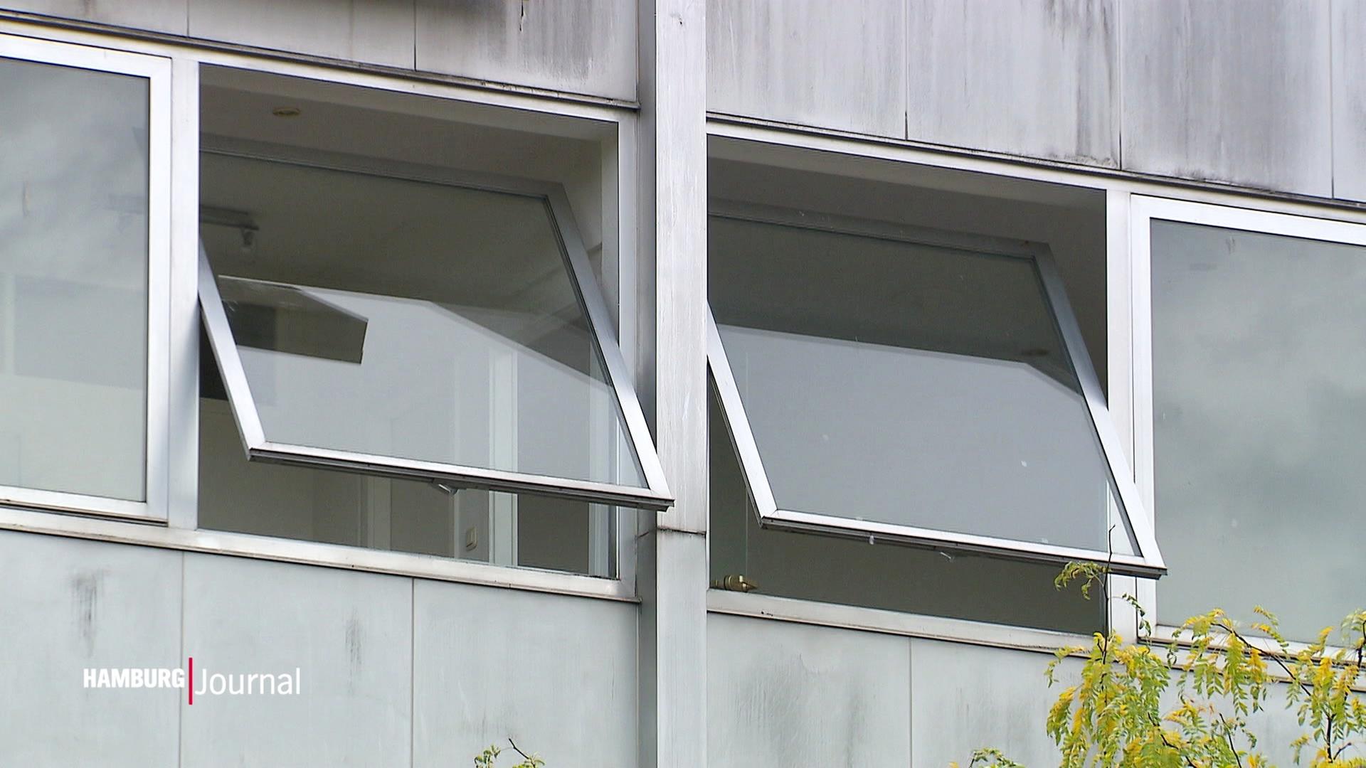 Zwei halb geöffnete Fenster in einem tristen Gebäude. | Screenshot