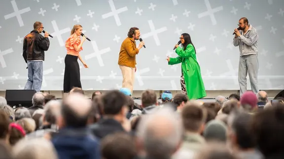 Fünf Sängerinnen und Sänger der Gruppe "The Real Group" auf einer Freilichtbühne.