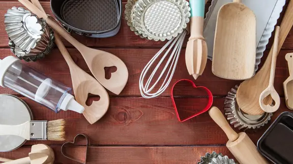 Backutensilien liegen nebeneinander auf einer Holzfläche