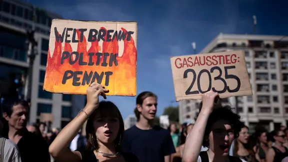 Demonstranten halten Schilder hoch, darunter "Welt brennt, Politik pennt"