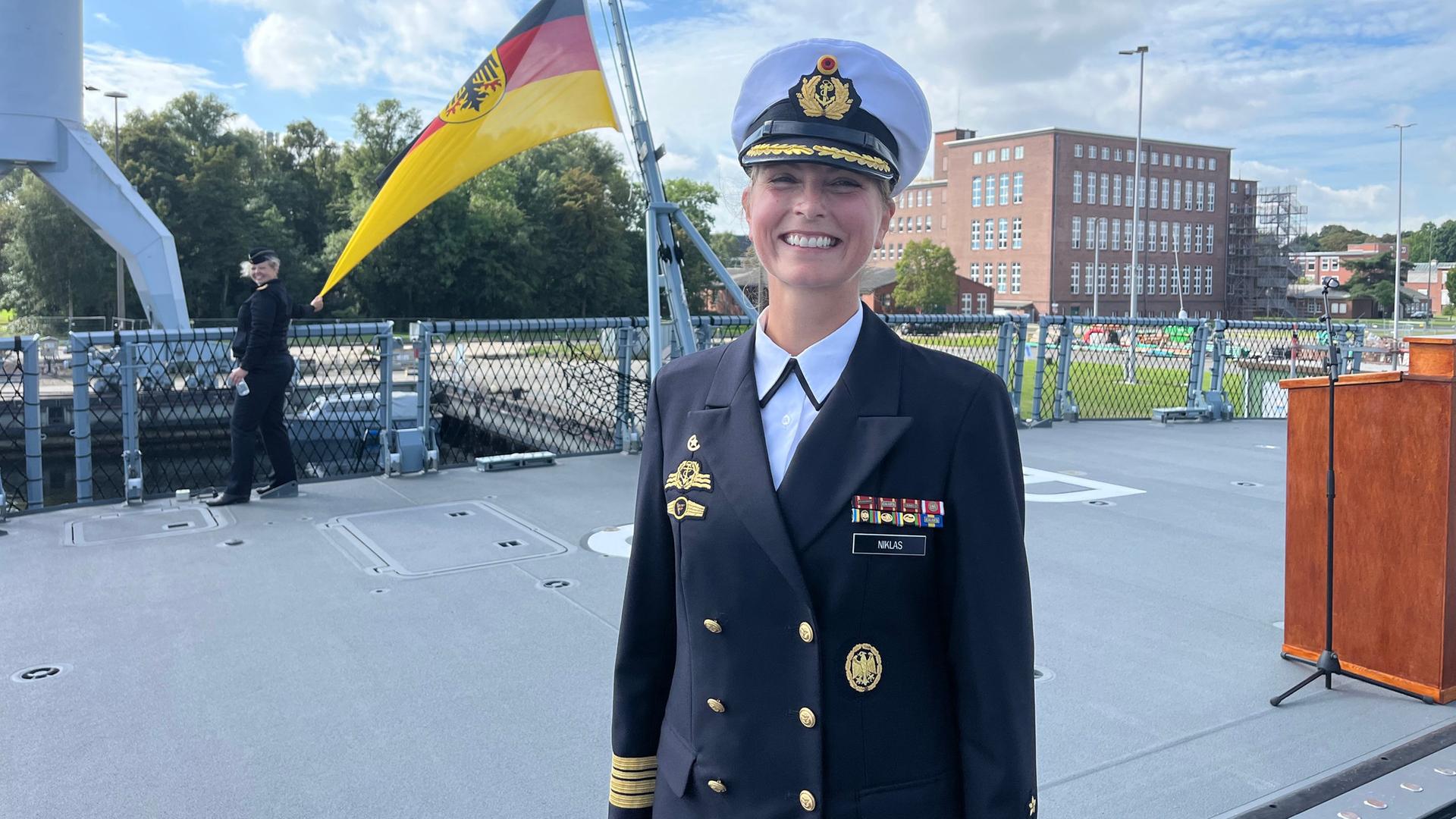 Ute Niklas steht strahlend an Bord der Fregatte 